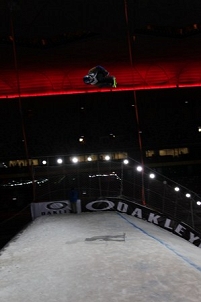 Snowboarder springt über eine Schanze
